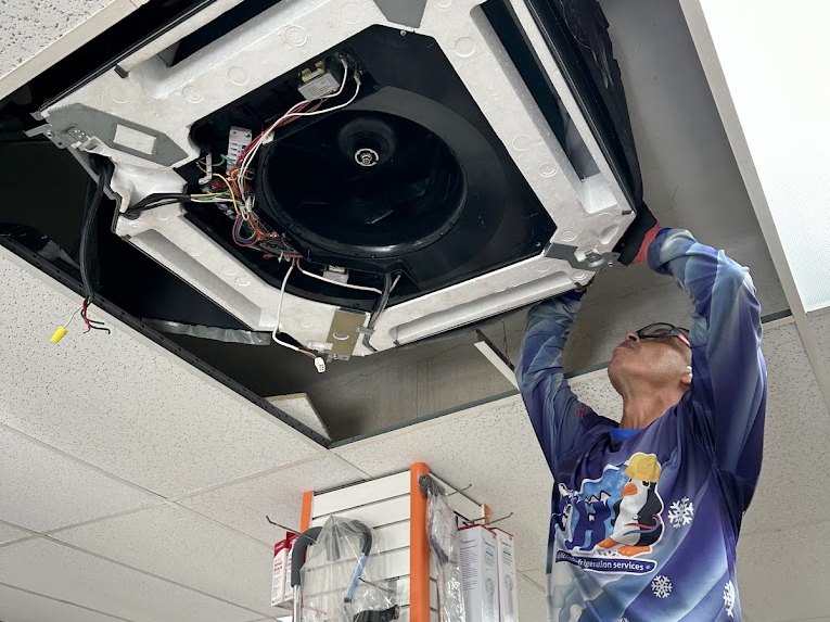 Félix dando servicio a una consola de cassette de techo en un comercio